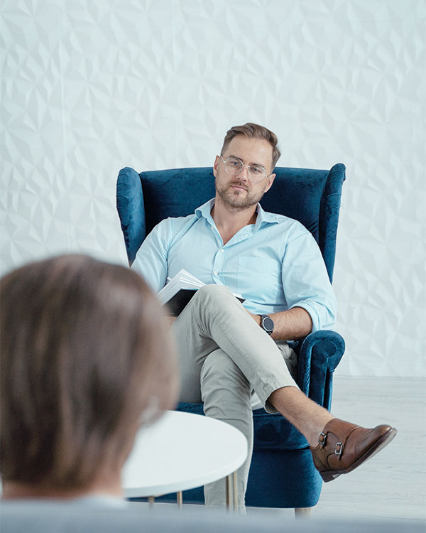 a male psychologist during mental health assessment with his client