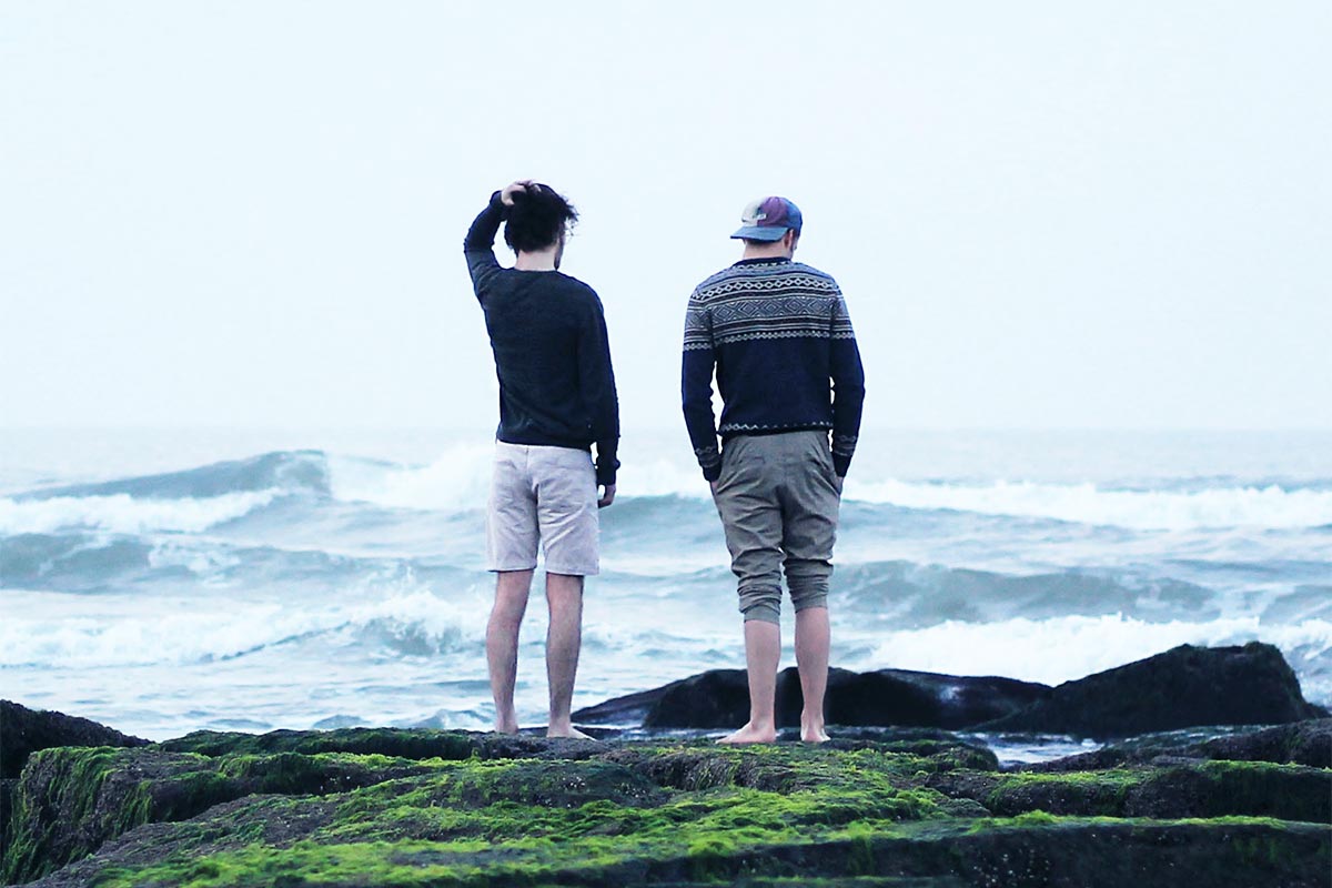 two friends having serious conversation near the ocean