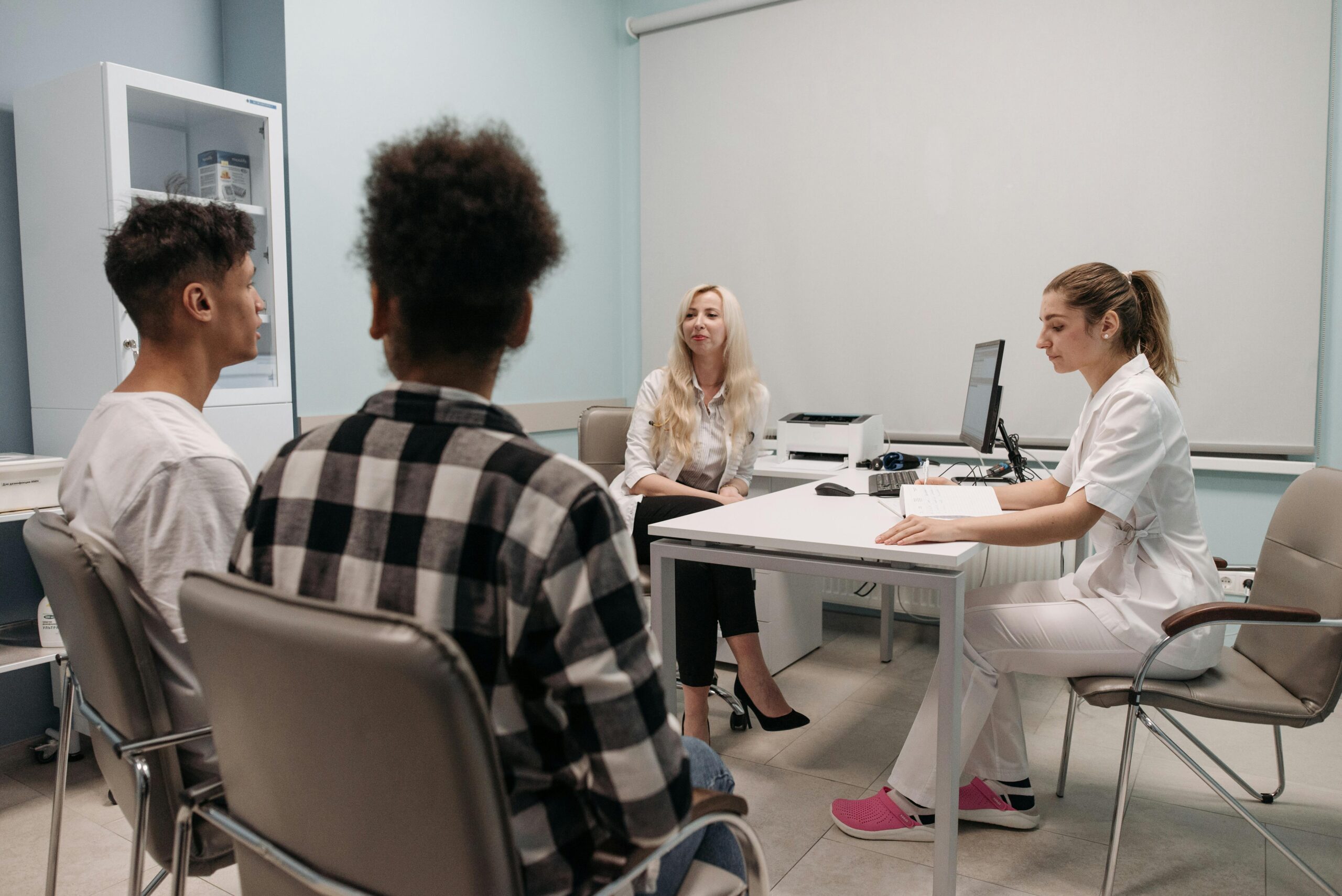 Two individuals meeting with a doctor and an assistant in a psychiatric hospital, highlighting what is a psych hospital and its role in treating major mental illness.