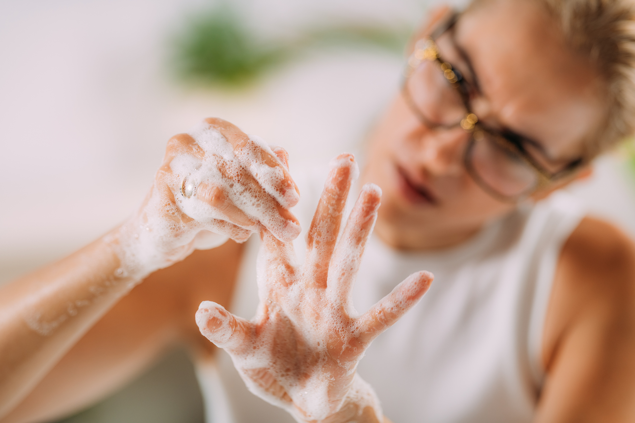 A woman washing her hands with meticulous attention, repeatedly scrubbing every inch with an obsessive focus, showcasing behaviors associated with OCD.