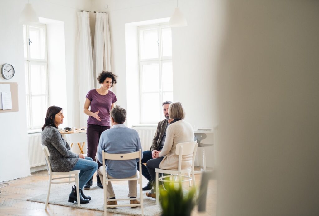 Group meeting with woman talking and four people