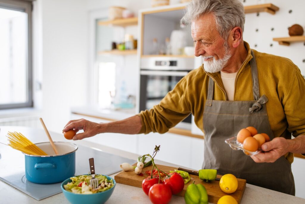 Senior man preparing food at home in kitchen