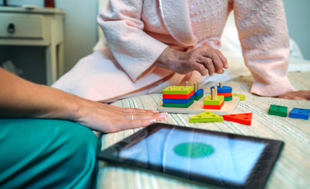 Senior woman playing cognitive game with assistant