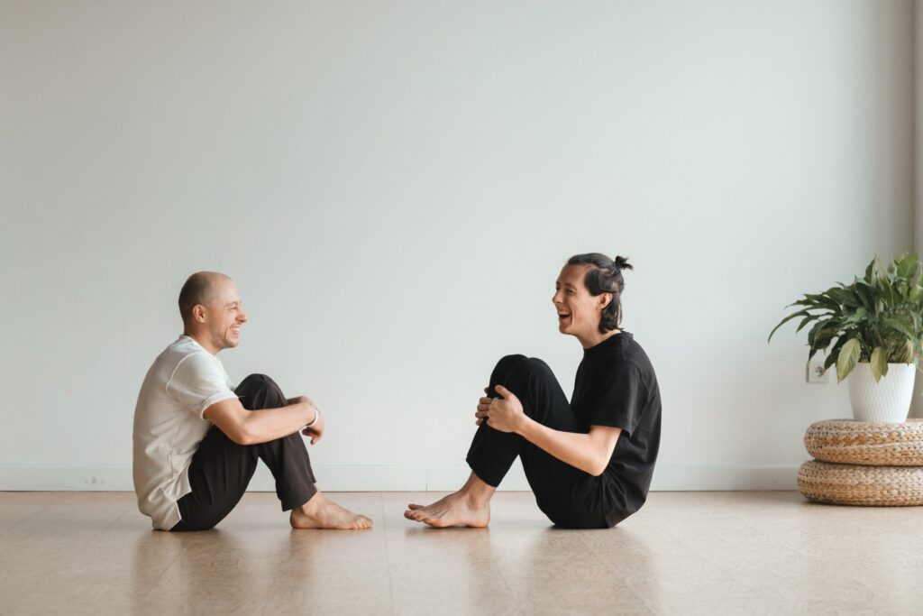 Two young athletes practice yoga in the gym joint