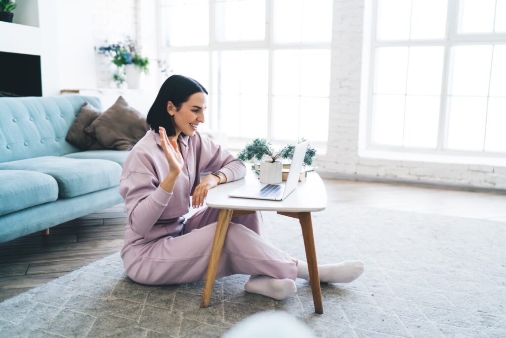 Woman smiling and waving during online video call