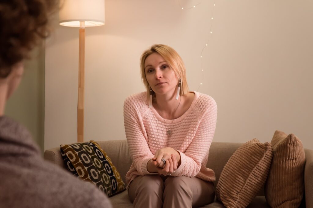 Woman with therapist sitting on couch indoors