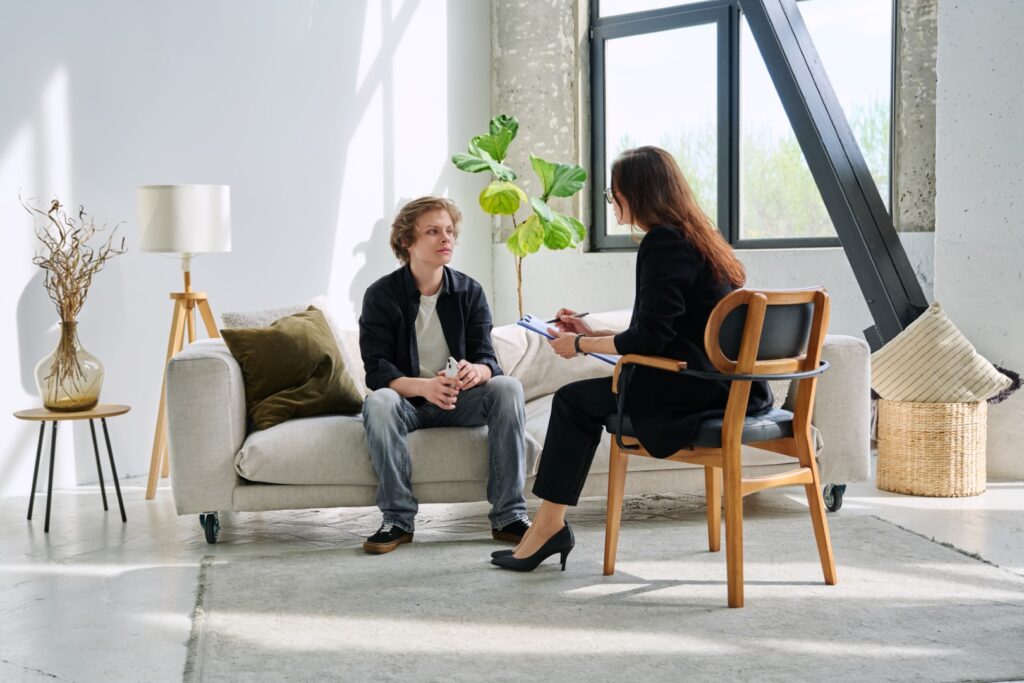 A client speaking with a therapist in a bright office